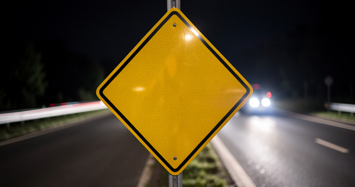 Panneau losange jaune route prioritaire rétroréfléchissant éclairé par phares de nuit