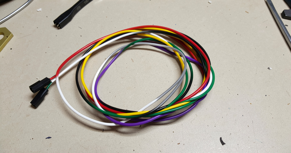 Faisceau de câbles d'autoradio avec fils rouge jaune noir blanc gris vert violet sur fond gris